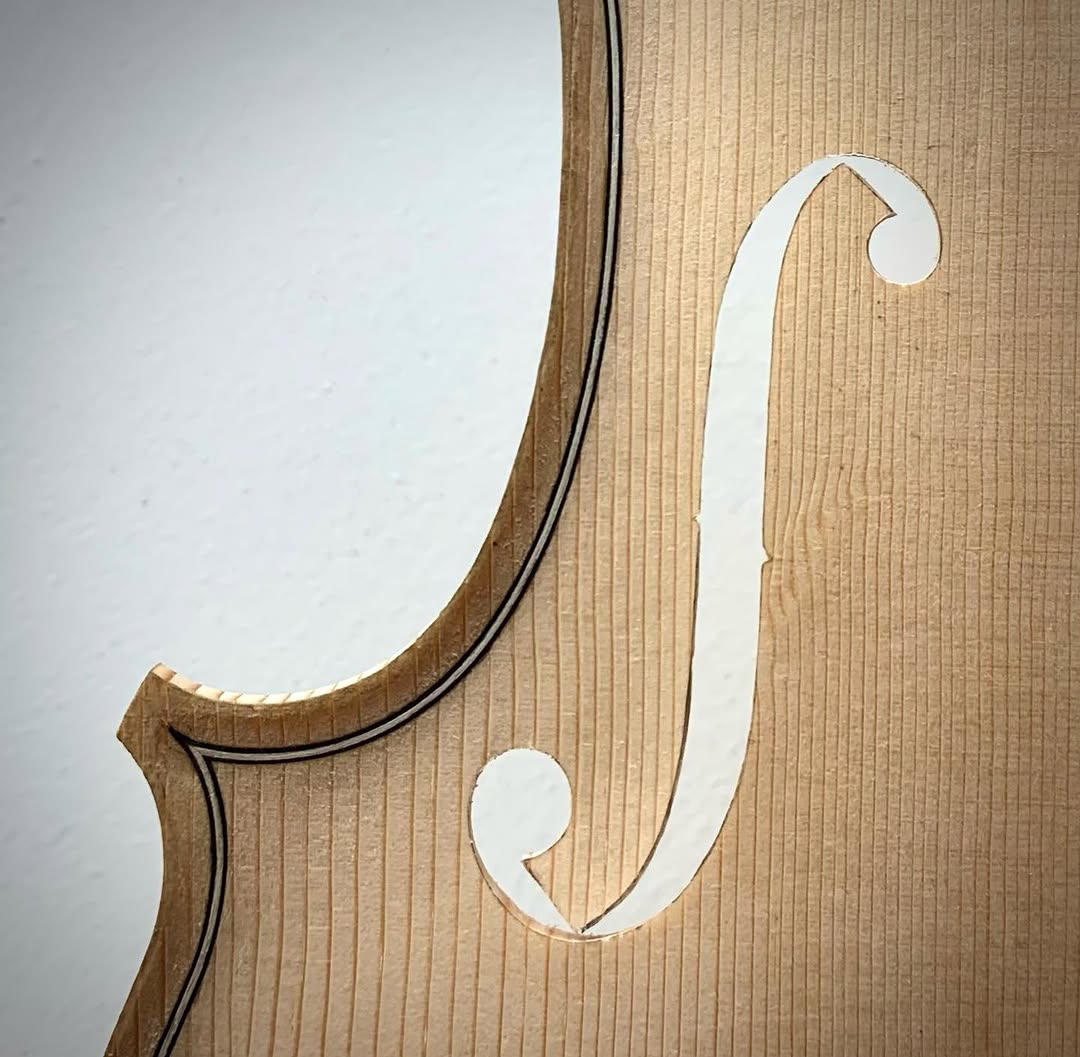 F-holes cut in violin top — precision craftsmanship
